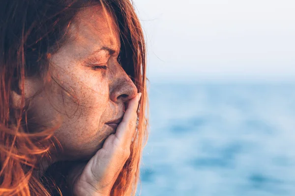 Jeune femme triste au bord de la mer — Photo