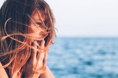 Genç kadın deniz kenarında üzgün