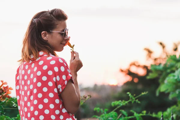 Young woman smelling flower in the garden — Stock Photo, Image