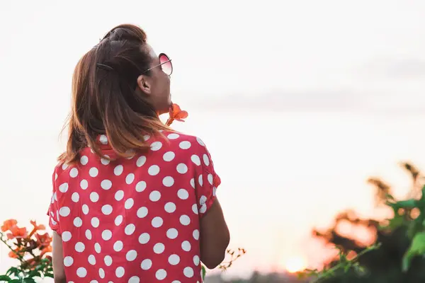 Young woman smelling flower in the garden — Stock Photo, Image