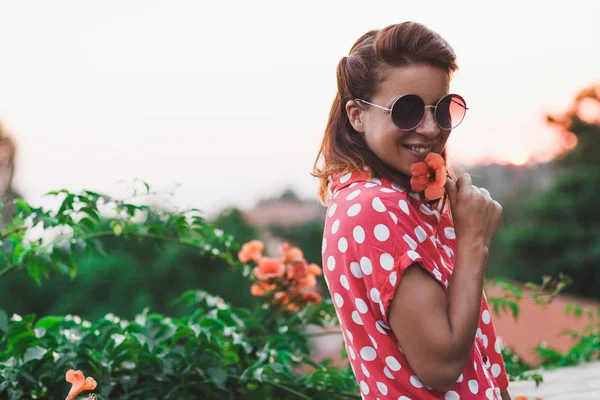 Young woman smelling flower in the garden — Stock Photo, Image