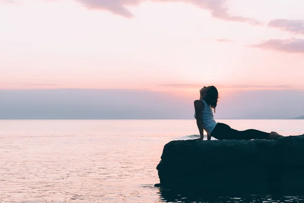 Mujer joven haciendo yoga junto al mar —  Fotos de Stock