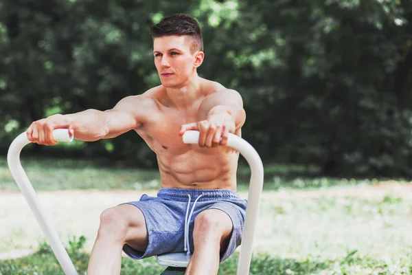 Jeune homme musclé pratiquant l'aviron — Photo