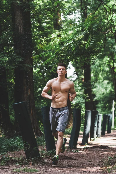 Genç adam parkta koşuyor. — Stok fotoğraf