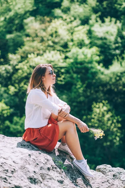 Ung kvinna i naturen med blommor — Stockfoto