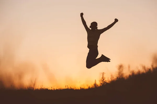 Silhouette Jumping Man Sunset Fiery Sky Background Mountain — Stock Photo, Image