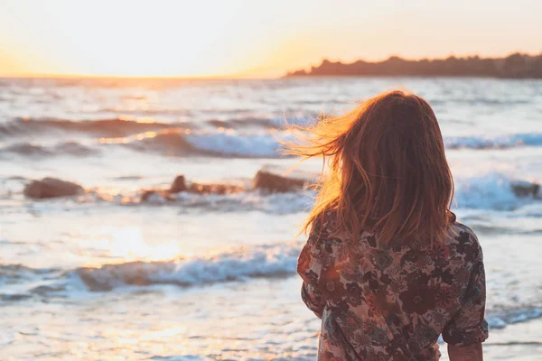 在海滩享受日落和波浪的年轻妇女 — 图库照片