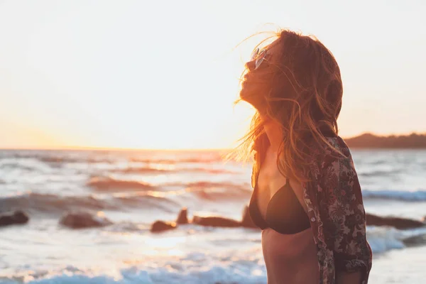 サンセット ビーチで波を楽しんでいる若い女性 — ストック写真
