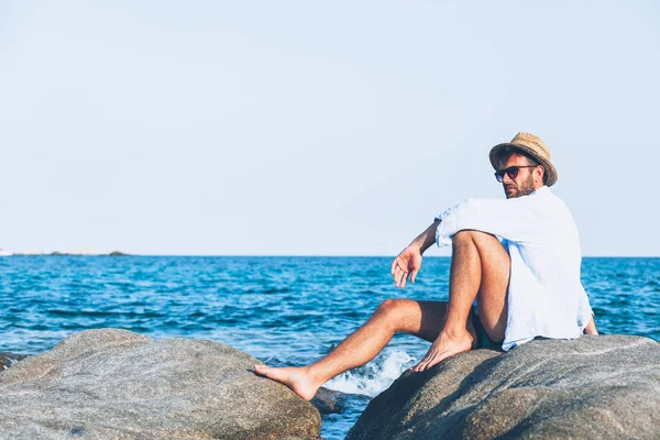 Giovane Uomo Che Rilassa Sulla Spiaggia Seduto Una Roccia Vicino — Foto Stock