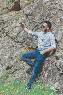 Doğanın içinde smartphone kullanarak güzel genç adam