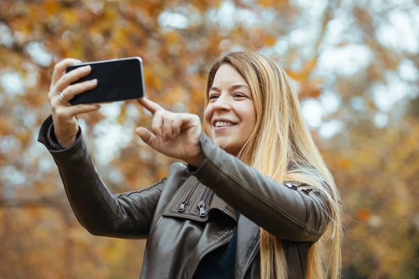 Fiatal Csinál Egy Szelfit Parkban Ősszel — Stock Fotó