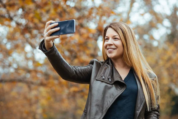 Fiatal Csinál Egy Szelfit Parkban Ősszel — Stock Fotó