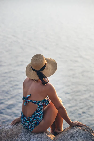 海辺の崖の上で夕日を楽しむ若い女性 — ストック写真