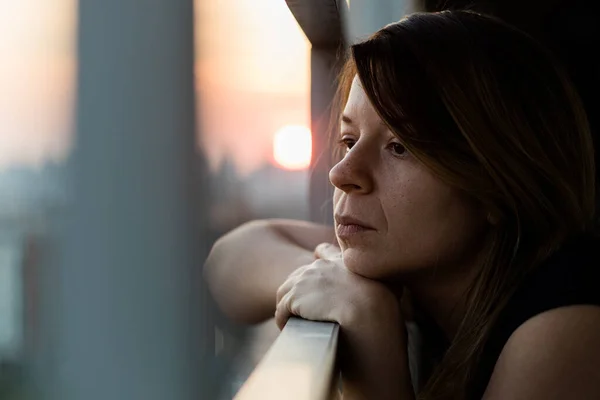 Νεαρή Θλιμμένη Γυναίκα Κοιτάζει Έξω Από Μπαλκόνι Μιας Πολυκατοικίας — Φωτογραφία Αρχείου
