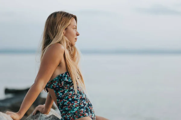 ビーチで夕日を楽しむ若い女性は — ストック写真