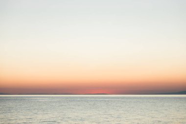 Sakin deniz ufkunda büyülü gün batımı