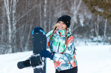Karlı dağlarda poz veren güzel genç bir kadın.