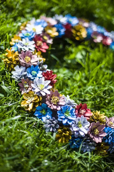 Altın saat çimenlerin üzerindeki konilerden yapılmış renkli bir kolye..