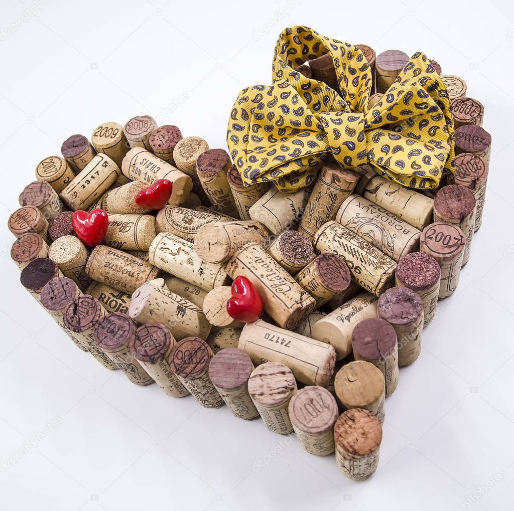 Father's day celebration valentine made of wine corks coupled with red hearts and a  a yellow paisley bow tie.