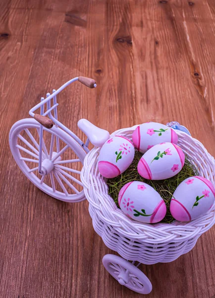 Çoklu renkli Paskalya yumurtalarıyla dolu sepetli üç tekerlekli oyuncak bisiklet..