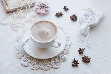 Şifoniyer eşarbında kahve fincanı ve hatıralar. Blok not ve inci kolye.