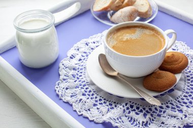 Kahvaltı lavantalı yatak tepsisi, yoğurt, ekmek ve kahve ile servis edilir.