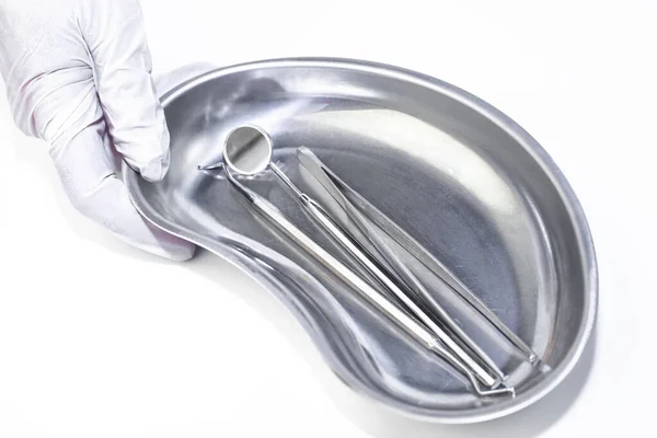 Tıbbi eldiven, paslanmaz çelik tepsi ve diş aletleri.