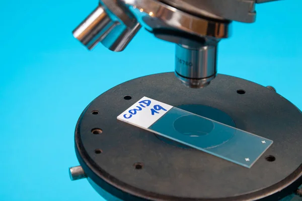 Koronavirüs COVID 19 'lu mikroskop merceği mikroskop sahnesinde pozitif çıktı. Resmi seçici odak ile kapat.