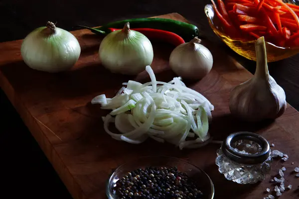 Doğranmış soğan, soğan, havuç kamışı, sarımsak, biber ve kesme tahtasında deniz tuzu. Dikkat çekmeyen, seçici odaklanma. Kimse..