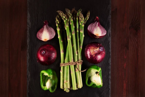 Bir demet taze kuşkonmaz soğanlı, soğanlı, yeşil biberli ve ahşap kaplamalı. Düz yatıyordu. Alçak tuş.