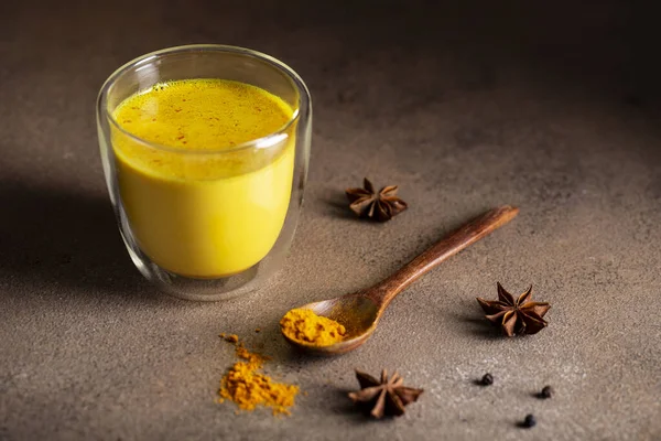Bardakta zerdeçal tozu olan altın süt koyu grunge arka planda, kopyalama alanı. Sağlık ve enerji arttırıcı, grip ilacı, doğal soğuk savaş içeceği. Temiz yemek, detoks, kilo kaybı konsepti