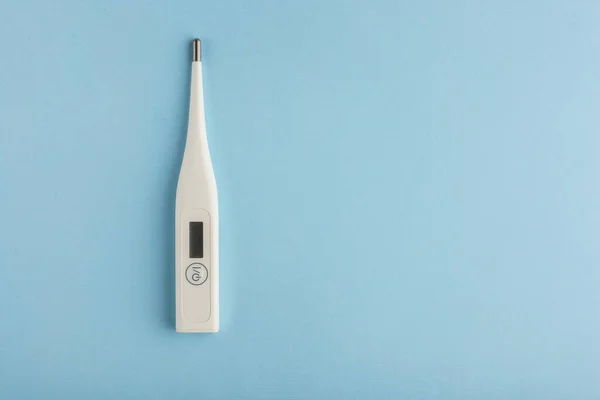 Mavi arka plan virüs salgını koronavirüs korumasında elektronik termometre