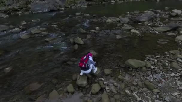 一个女孩在一条山河里打水 一次去喀尔巴阡山脉的旅行 从一架无人驾驶飞机上俯瞰风景 — 图库视频影像