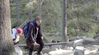 Kederli bir şekilde seyahat eden turist, macera arayışında, nehrin kenarında, ormanın içinde, dağın zirvesine doğru yürüyor.