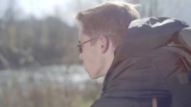 Kederli bir şekilde seyahat eden turist, macera arayışında, nehrin kenarında, ormanın içinde, dağın zirvesine doğru yürüyor.