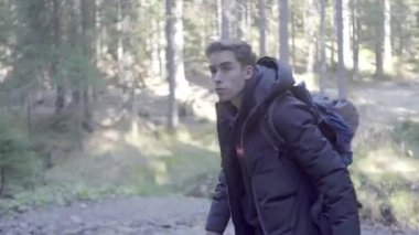 Kederli bir şekilde seyahat eden turist, macera arayışında, nehrin kenarında, ormanın içinde, dağın zirvesine doğru yürüyor.