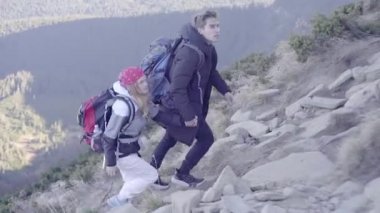 Bir kızla yürüyüşe çıkan bir adam, dağların tepesine çıkar, nehirden geçer ve dağlardaki ormana gider.