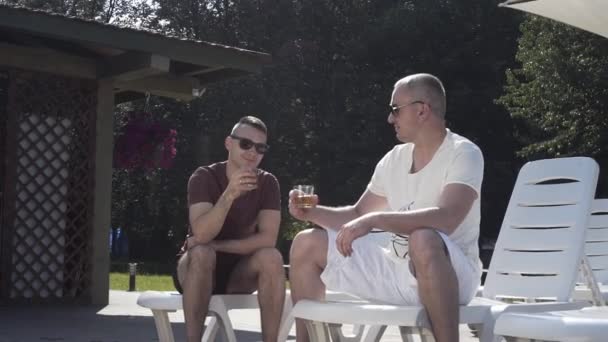 休暇中の二人の男人生について話しウイスキーを飲む — ストック動画