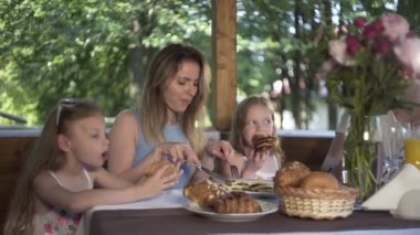 Aile yaz akşamı yemek yiyor. Masa, açık hava, çardak, kahvaltı.