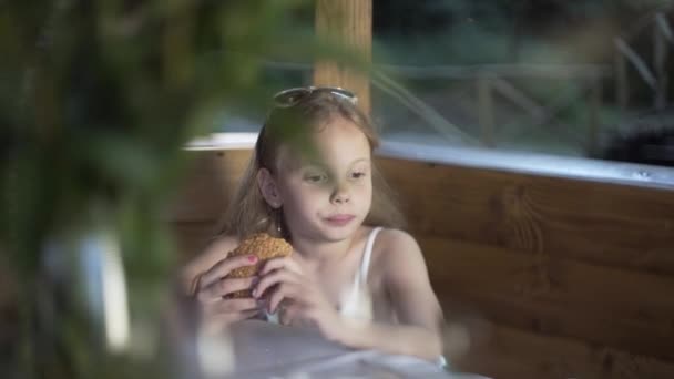 Mädchen Beim Frühstück Das Ein Brötchen Isst Gedeckter Tisch Draußen — Stockvideo