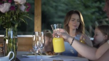 Aile yaz akşamı yemek yiyor. Masa, açık hava, çardak, kahvaltı.