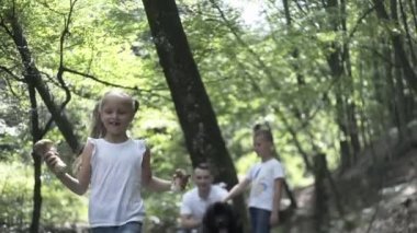 Aile ormanda yürür. Mutlu aile babası, oğlu ve kızı kozalaklı ormanda el ele yürüyor. Ebeveynler bir çocuğa güzel ağaçlar gösteriyor. Çocuklar mantar toplar.