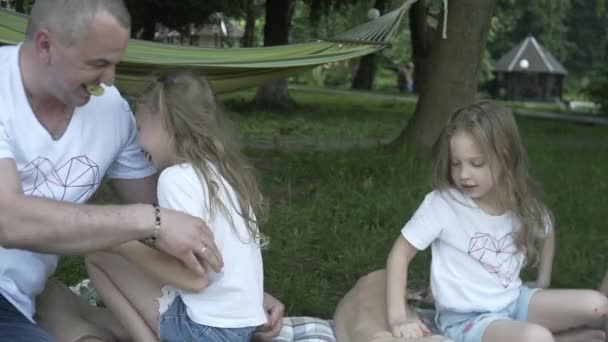 幸せな家族のピクニック屋外牧草地に座っている 公園での週末の食事や飲み物で楽しい親と子供肯定的な気分 子供時代 — ストック動画