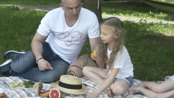 Familias Felices Haciendo Picnic Aire Libre Sentadas Prado Padres Hijos — Vídeo de stock