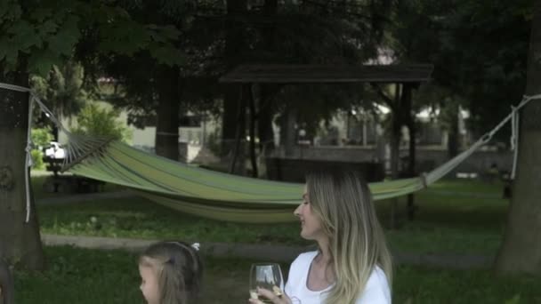 快乐的家庭坐在草地上在户外野餐 父母和孩子周末在公园里玩的开心 一起吃喝玩乐积极的情绪 为人父母 童年时代 — 图库视频影像