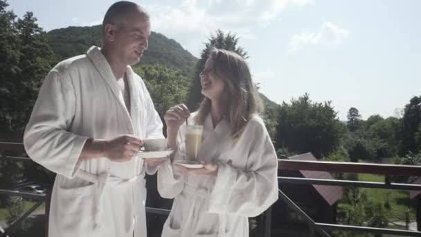 夫と妻は休暇で山のバルコニーでコーヒーを飲む — ストック動画