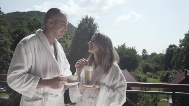 夫と妻は休暇で山のバルコニーでコーヒーを飲む — ストック動画