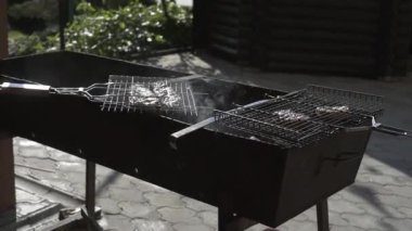 Adam ızgarada, balıkta, biftekte barbekü yapıyor.