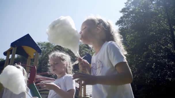 女の子は遊び場で綿菓子を食べる — ストック動画