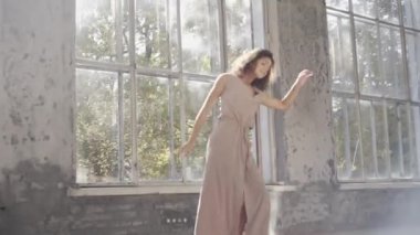 Uzun saçlı, modern dansçı kadın. Çağdaş serbest stil. Stüdyoda büyük camlı beyaz bir kız dans ediyor. Seksi kız dans hareketleri yapıyor..